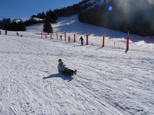 a person is sitting in the snow on a snowboard at Chateau de La Lanette in Saléchan