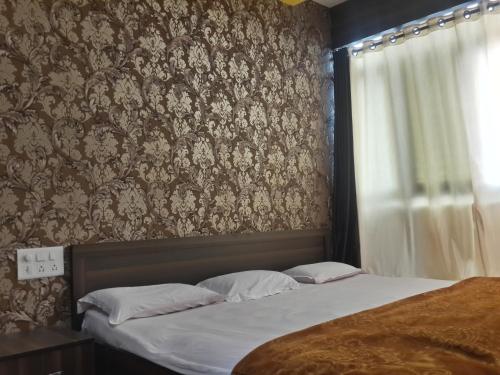 1 dormitorio con 1 cama y papel pintado con motivos florales en Hotel Holiday Era, en Aurangabad