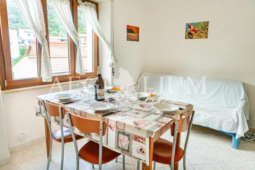 ein Esszimmer mit einem Tisch mit Stühlen und einem Sofa in der Unterkunft Rudy in Campese