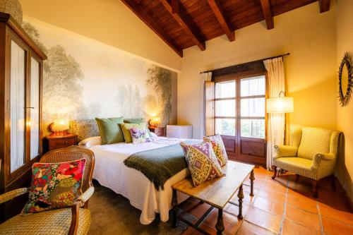 ein Schlafzimmer mit einem Bett und zwei Stühlen in der Unterkunft Hotel Boutique Barosse Jaca in Jaca