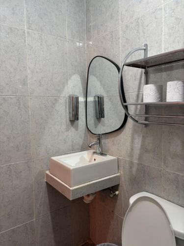 a bathroom with a sink and a mirror and a toilet at Apartment #4 for 4 Central-WiFi-consulate in Matamoros