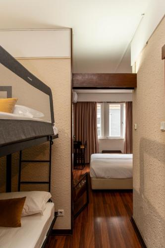 a bedroom with two bunk beds and a bathroom at WOT Porto Soul in Porto