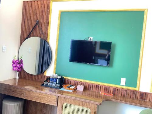 een kamer met een spiegel en een televisie aan de muur bij Hotel Kim Long Hồ Tràm in Kon Rung (1)