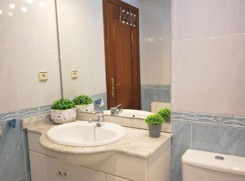 een badkamer met een wastafel en een spiegel en een toilet bij Gaudi Contemporani in Mataró