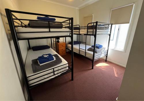 una habitación con tres literas en una habitación en The Sundowner Cabin & Tourist Park, en Whyalla