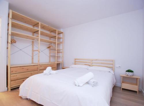 Un dormitorio con una gran cama blanca con dos almohadas. en Santa Maria apartment, en Vilassar de Mar
