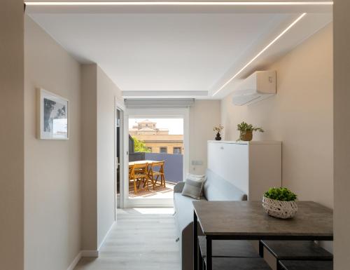 a kitchen and living room with a table and a refrigerator at Aparthotel Vilassar in Vilassar de Mar
