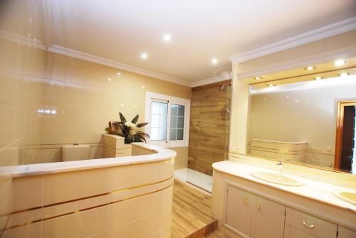 ein Badezimmer mit Waschbecken und Spiegel in der Unterkunft Villa Magnolia in Mataró