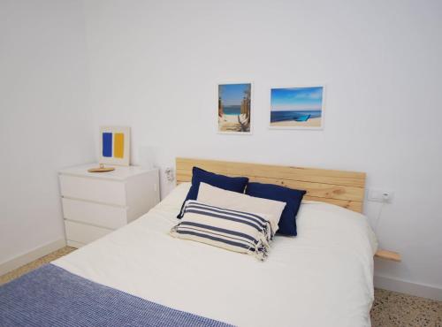 a bedroom with a white bed with blue pillows at Can Josep in Vilassar de Mar