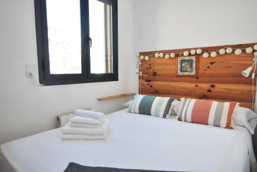 una camera da letto con un grande letto bianco con testiera in legno di Waves and sky a Montgat