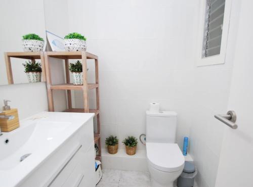 a white bathroom with a toilet and a sink at Can Josep in Vilassar de Mar