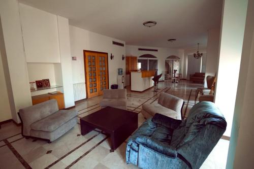 Una sala de estar con un sofá y sillas y una mesa. en Domaine de Chouchene, en Şaḩrat al Qashsh