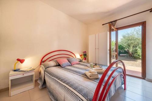 een slaapkamer met een bed en een groot raam bij Perfectly located flat in San Teodoro in San Teodoro