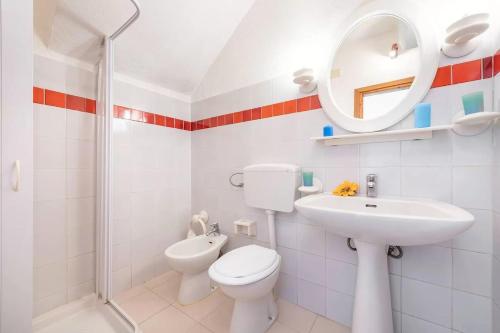 een badkamer met een toilet, een wastafel en een spiegel bij Perfectly located flat in San Teodoro in San Teodoro