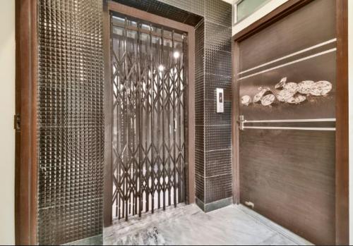 パトナーにあるHotel bihanの金属製のドアが付いたウォークインシャワー