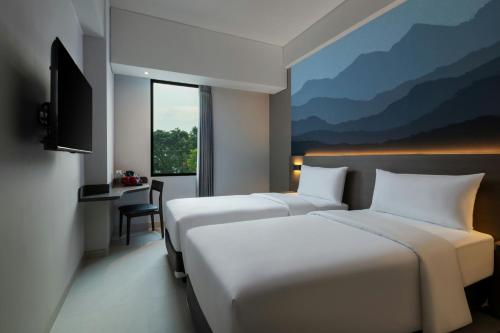 SimparにあるHotel Neo Kota Baru Parahyanganのベッドが2つと窓があるホテルの部屋