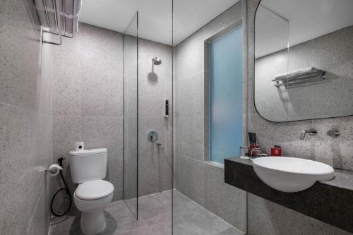 SimparにあるHotel Neo Kota Baru Parahyanganのトイレ、洗面台、シャワー付きのバスルーム