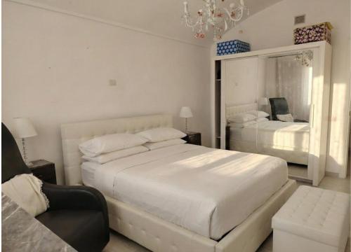 una camera da letto bianca con due letti e un lampadario di Da Marilena a Sorso