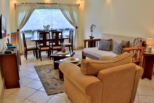 a living room with a couch and a table at The Oaks Tamarindo Pool Front Condominiums fast wifi in Tamarindo