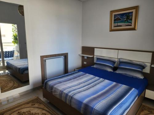 a bedroom with a bed with a blue comforter at Fantastic Appartment SeaView Sousse in Akouda