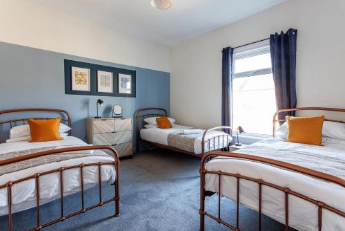 een slaapkamer met twee bedden en een raam bij Beaconsfield Stay Family & Work Friendly in Darlington