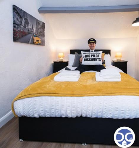 a man holding a sign on a bed at Large 1Bed Contractor & Pilot Flat - FREE Parking - FREE WiFI in Castle Donington