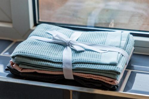 een stapel opgevouwen handdoeken met een strik op een raam bij Beaconsfield Stay Family & Work Friendly in Darlington