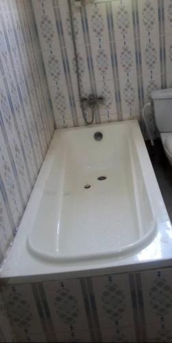 a white sink in a bathroom with a toilet at 2-bedroom equipped apartment in Bakote