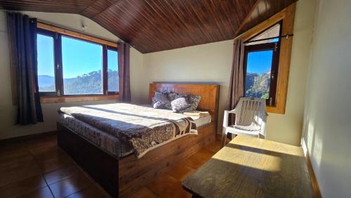 a bedroom with a bed in a room with windows at Thakur homes- couple and family friendly homestay in Shimla