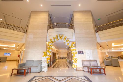 um saguão com uma escada em espiral decorada com balões amarelos e brancos em فندق ميزاب السابق 2 em Meca