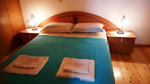 um quarto com uma cama com 2 toalhas e 2 candeeiros em Traditional House Astro em Gerani