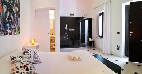 a bedroom with a white bed with slippers on it at La Bella Trani - Suites and B&B in Trani