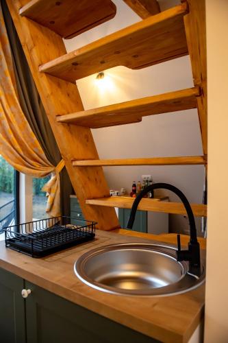 a kitchen with a sink and a wooden counter at A-frame Dor De Aer in Herneacova
