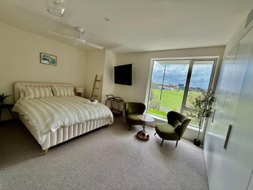 a bedroom with a bed and a large window at Port Melbourne Marvel in Melbourne
