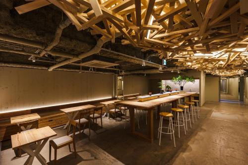 a bar with wooden tables and stools in a room at 2Z - Doyanen Hotels in Osaka