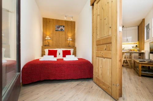 a bedroom with a bed with a red bedspread at Apremont in Chamonix-Mont-Blanc