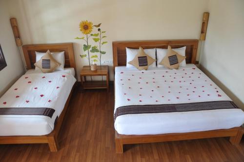 two beds in a room with two beds sidx sidx sidx at Trinity Family Inn in Nyaung Shwe