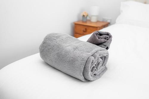 ein Handtuch auf dem Bett in der Unterkunft Modern Two Bedroom Home with Parking in Sherborne Saint John