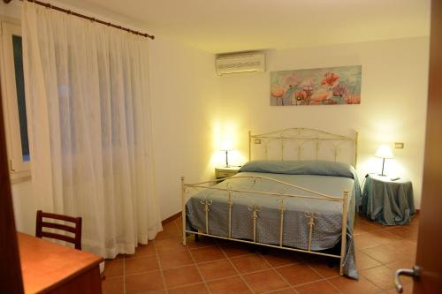 um quarto com uma cama, 2 candeeiros e uma janela em Villa Cornula em Santa Maria al Bagno