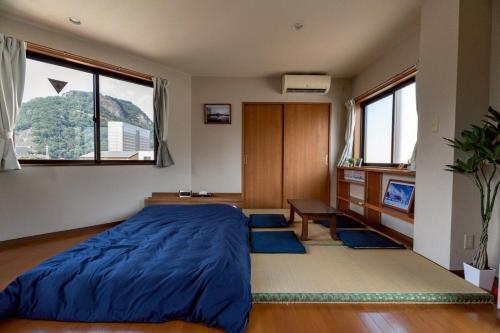 ein Schlafzimmer mit einem großen blauen Bett und einem Schreibtisch in der Unterkunft Otsuki in Oishi