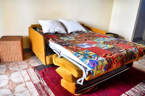 uma cama com um edredão colorido num quarto em Kribi Host em Kribi