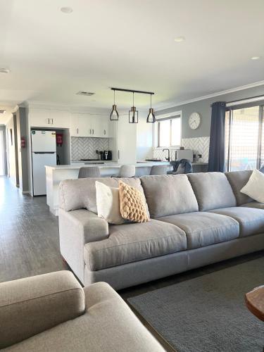 a living room with a couch and a kitchen at Telopea House Mount Gambier in Worrolong