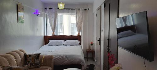 a small bedroom with a bed and a window at The cozy nook - Thindigua in Kiambu