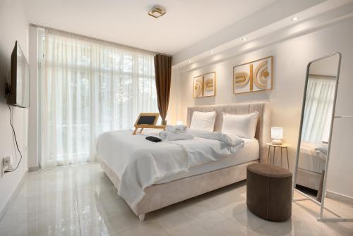 a bedroom with a large bed with a laptop on it at Estia Premium Apartments - Luxury Kingbed Studio Vackhou 1 in Thessaloniki