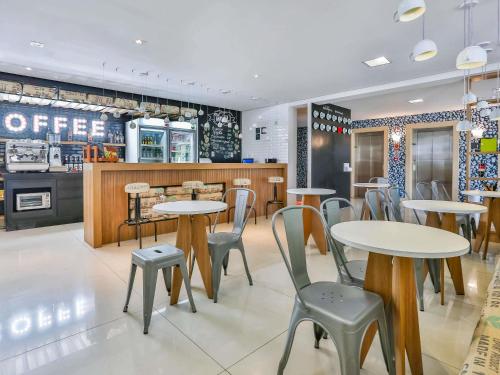维多利亚-达孔基斯塔ibis Styles Vitoria da Conquista的有桌椅和柜台的餐厅