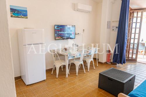 una sala da pranzo con tavolo e frigorifero di Fortuna a Campese