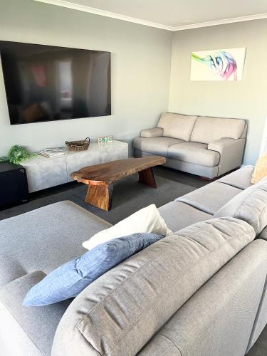 a living room with a couch and a coffee table at Telopea House Mount Gambier in Worrolong