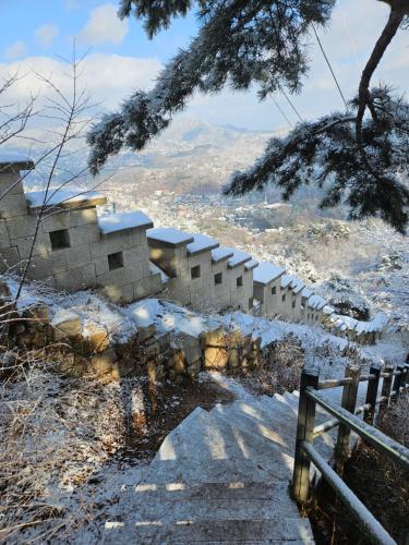 een gebouw op een heuvel met sneeuw op de grond bij Inwangsan Stay in Seoul