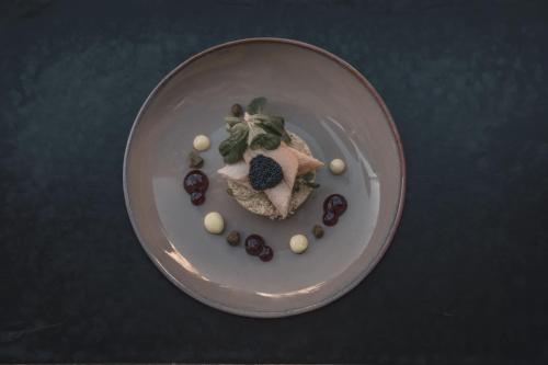 un plato de comida con un trozo de carne y fruta en Hotel Andreas Hofer, en Sankt Leonhard im Pitztal