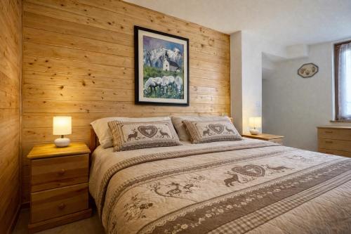 een slaapkamer met een bed met een houten muur bij Maso Patrizia - Rifugio caldo tra le vette in Pieve Tesino